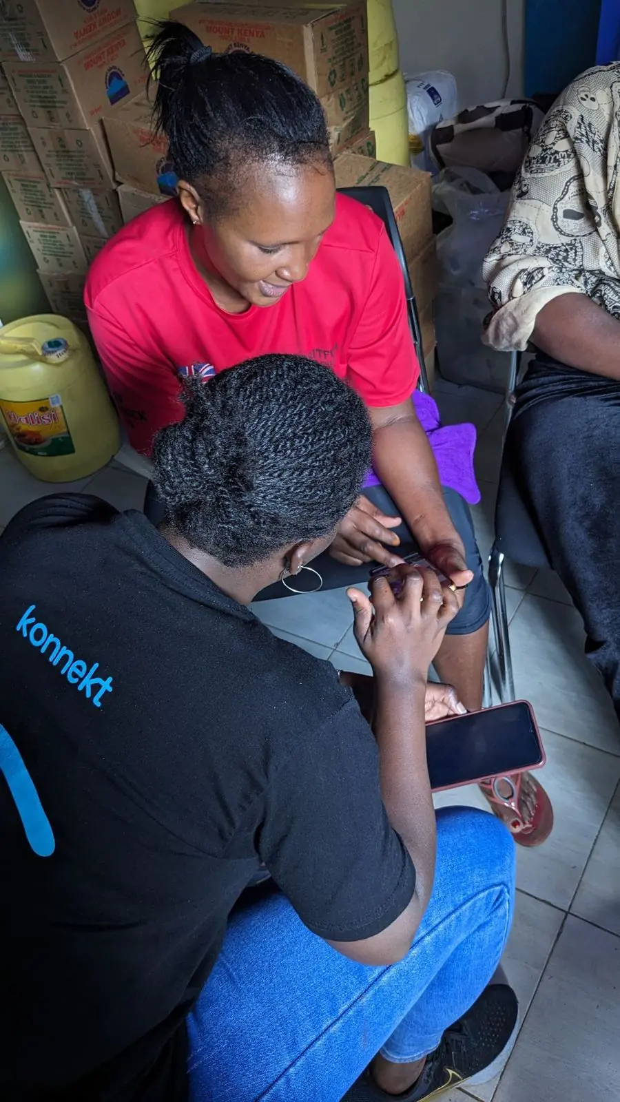A konnekt Academy facilitator coaches a woman on her phone
