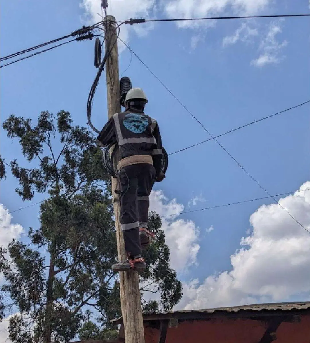 A konnekt technician working at the top of a utility pole